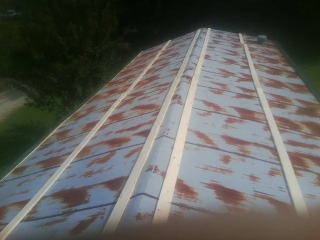 Rusted metal roof panels with new wood purlins before replacement — Storm Damage Roof Repair in Delton by Roofing Brothers