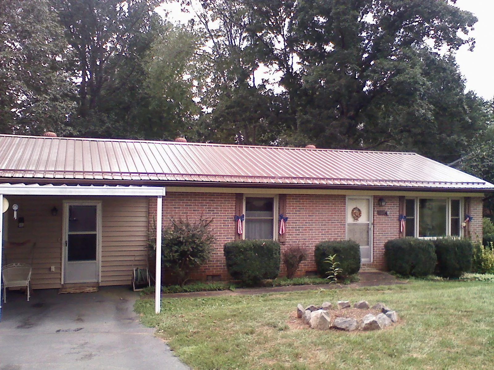 Bronze metal roof and carport on a brick ranch home — Roof Repair work by our crew in Delton